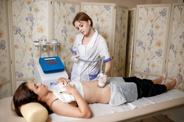 Equipo de masaje de vacío. Tratamiento anticelulítico de la corrección corporal. Dispositivo de pérdida de peso. Mujer y médico en el salón de medicina. Salón de belleza. masaje al vacío del abdomen. Masaje anticellulita — Foto de Stock