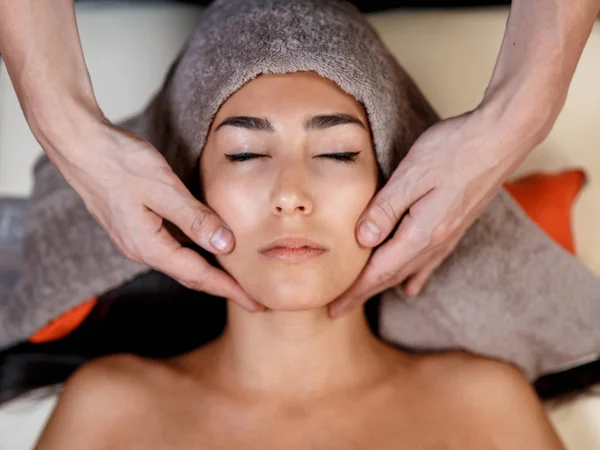 Face massage. Close-up of young woman getting spa massage treatment at beauty spa salon.Spa skin and body care. Facial — Stock Photo, Image