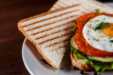 Jambonlu sandviç kulübü, pastırma, domates dolması, salatalık turşusu, kızarmış yumurta, peynir, sos ve salata. Sandviç...