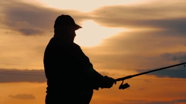 Silhouette fisherman throwing fishing rod in river on background evening sunset. Beautiful evening sunset during fishing on river. Sport hobby fishing. — Stock Footage Silhouette fisherman throwing fishing rod in river on background evening sunset. Beautiful evening sunset during fishing on river. Sport hobby fishing. Royalty Free Stock Footage