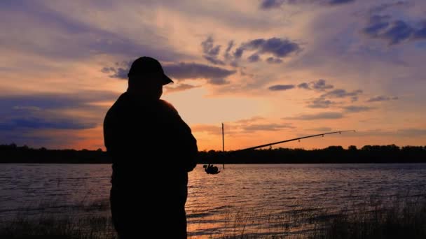 Silhouette fisherman throwing fishing rod in river on background evening sunset. Beautiful evening sunset during fishing on river. Sport hobby fishing. — Stock Footage Silhouette fisherman throwing fishing rod in river on background evening sunset. Beautiful evening sunset during fishing on river. Sport hobby fishing. Video Clip