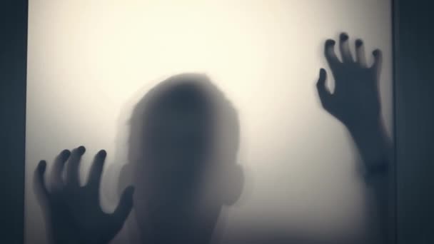 Possessed boy scratching glass with hands, creepy female silhouette ...