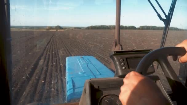 Farmer vezető traktor művelő területen. Mezőgazdasági munkák traktoron.