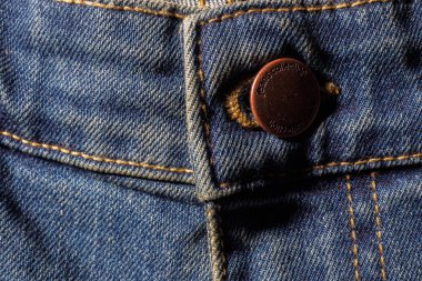 Mavi jeans doku düğmesini ve ZIP detayları ile