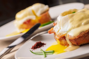 Kahvaltı Yumurta Benedict - tost İngilizce muffins, pastırma, jambon, haşlanmış yumurta, otlar ve lezzetli tereyağı hollandaise sosu olduğunu. 