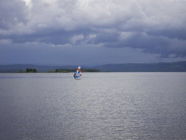suda duran, o kadar onun surfboard adımlar önce rüzgar ve dalgalar için bekleyen sörfçü
