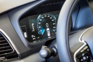 Luxury car interior details. Dashboard and steering wheel. Modern car illuminated dashboard close-up. Speedometer. Speed control. Digital screen of telling speed of the car.
