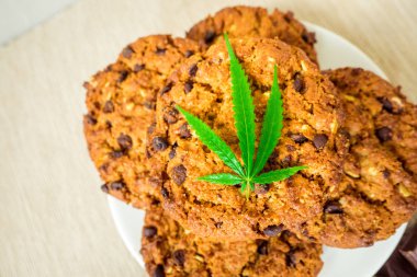 Cbd esrar ve yaprak garnitür ve esrar tomurcukları ile lezzetli ev yapımı kurabiyeler. Esrar tomurcukları kavramı ile esrar bitki yemek konservesi. Gıda olarak kullanılmak üzere tıbbi esrar tedavisi.