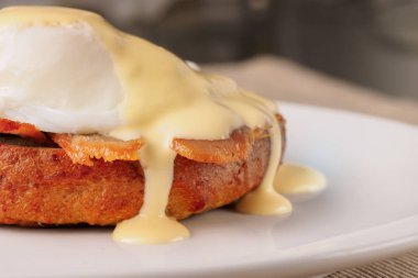 Kahvaltı Yumurta Benedict - tost İngilizce muffins, pastırma, jambon, haşlanmış yumurta, otlar ve lezzetli tereyağı hollandaise sosu olduğunu. 