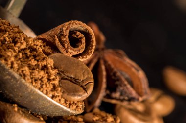 vintage bir çekilmiş kahve kaşığı tarçın sopayla. baharat ile kahve. Gıda arka plan üzerinde koyu taş tablo. Makro yakın çekim yansıma.
