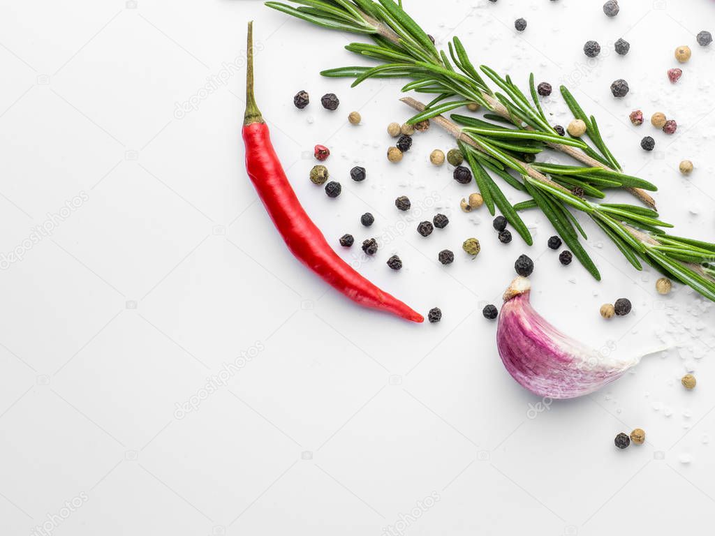 Red hot chilli pepper, garlic and rosemary with sea salt and colored pepper on white background