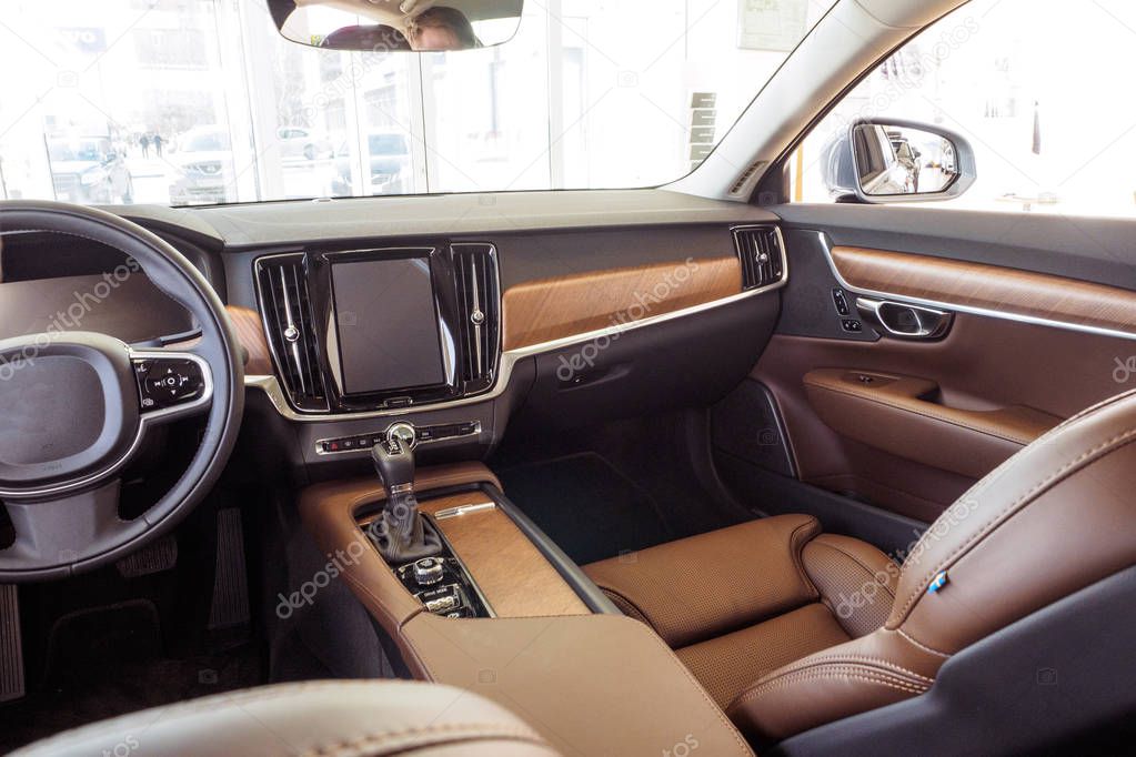 Interior of prestige modern car. Comfortable leather seats. Light brown perforated leather cockpit. Car inside driver place. Front seats with steering wheel & dashboard.