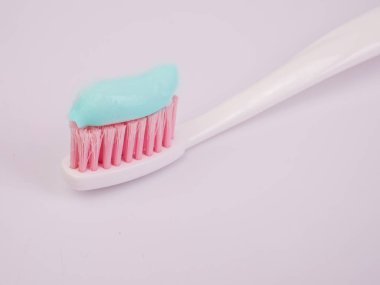 Diş macunu üzerinde beyaz bir ışık arka plan bir diş fırçası yakın çekim