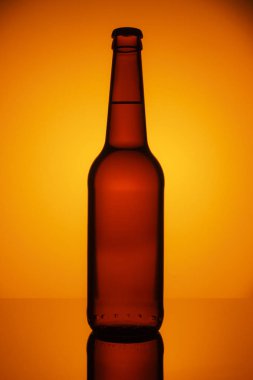 Bira veya turuncu degrade arka plan üzerinde izole kırpma yolu ile elma şarabı şişe.