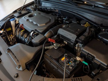 Çalıştırma motoru için bakır kıskaçlı elektrik kablosu ile şarj edilen araba aküsü.