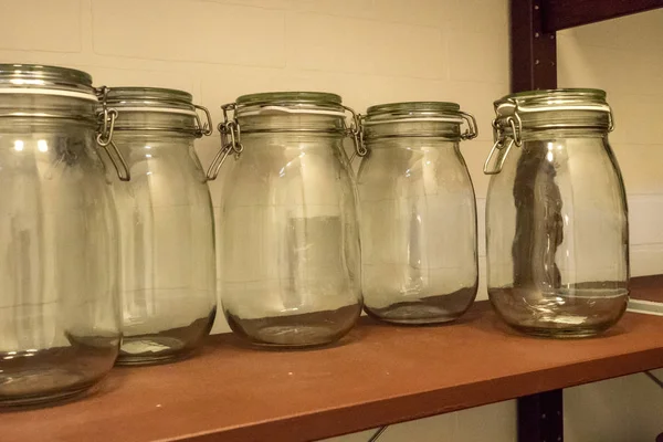 Glass empty jars on the shelf. Empty Bale Square Glass Jar with Swing Top.