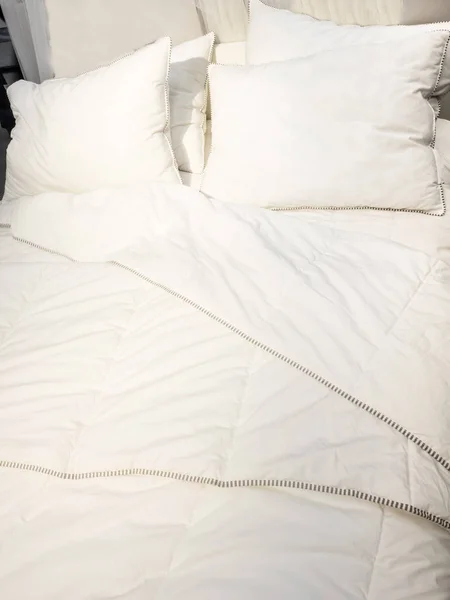 white pillow on bed and with wrinkle messy blanket in bedroom, from sleeping in a long night, an unmade bed in hotel bedroom with white blanket.