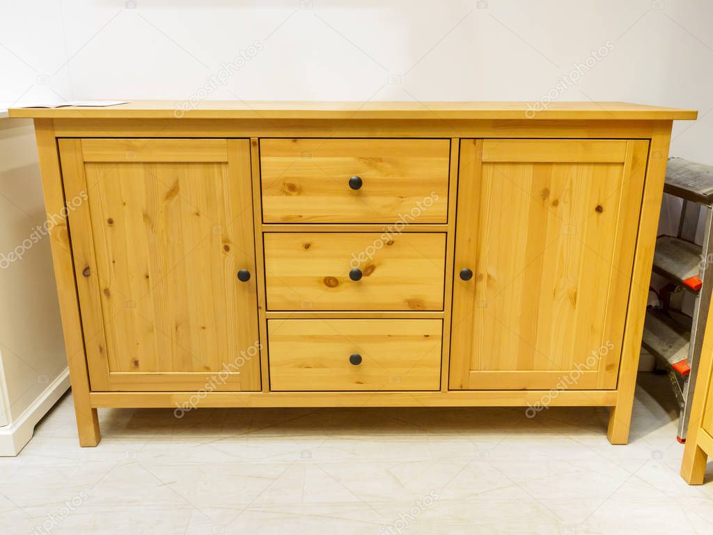 Wooden chest of drawers on interior background.