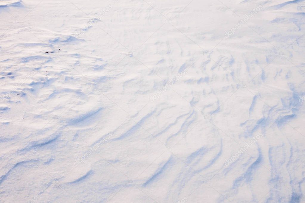 High angle view of snow texture, background with copy space. Icy texture of snow after a blizzard on a sunny morning.