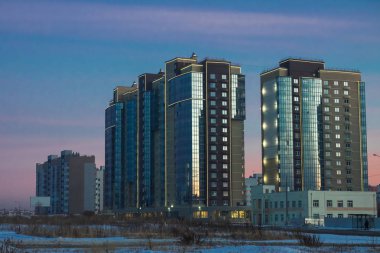 Modern bina cephe günbatımı mavi gökyüzünün yansıması ile. Apartmanlar arasında modern avlu, görüntüleme.