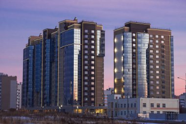 Modern bina cephe günbatımı mavi gökyüzünün yansıması ile. Apartmanlar arasında modern avlu, görüntüleme.