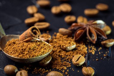 Kahve çekirdekleri çekilmiş kahve ve oryantal baharatlar, anason ve tarçın vintage bir kaşıkla. Karanlık bir taş zemin üzerinde. Üstten görünüm. Kopya alanı.