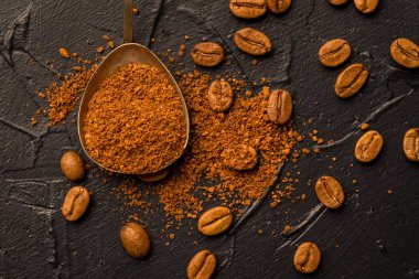 Kahve çekirdekleri çekilmiş kahve ve oryantal baharatlar, anason ve tarçın vintage bir kaşıkla. Karanlık bir taş zemin üzerinde. Üstten görünüm. Kopya alanı.