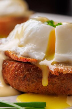 Kahvaltı Yumurta Benedict - tost İngilizce muffins, pastırma, jambon, haşlanmış yumurta, otlar ve lezzetli tereyağı hollandaise sosu olduğunu. 