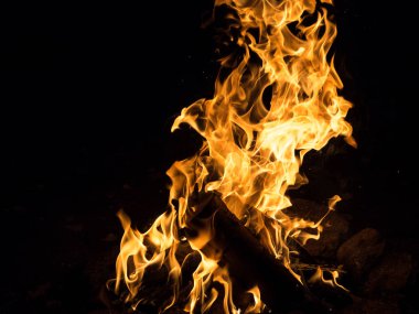 Yakın çekim ve kırmızı turuncu sarı renk detay doku ve soyut şekil siyah arka plan üzerine ateş.