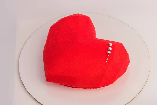 Cake in the shape of heart on Valentine\'s Day. Cake in the form of a red heart on white background.