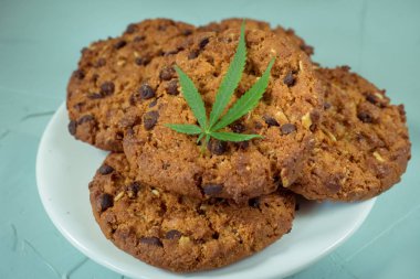 Delicious homemade Cookies with CBD cannabis and leaf garnish and buds of marijuana. A can of cannabis buds Concept of cooking with cannabis herb. Treatment of medical marijuana for use in food. clipart