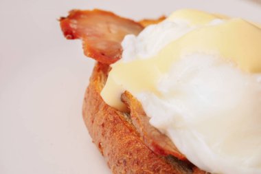 Kahvaltı Yumurta Benedict - tost İngilizce muffins, pastırma, jambon, haşlanmış yumurta, otlar ve lezzetli tereyağı hollandaise sosu olduğunu. 