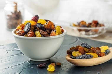 Seramik kase kuru üzüm ürün çeşitliliği, sarı, mavi, siyah, altın renkli kuru üzüm ve tahta kaşık mutfak masasında. Sağlıklı snack, diyet ürün iyi bir yaşam için. kopya alanı, Vega gıda
