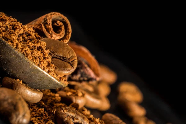 vintage bir çekilmiş kahve kaşığı tarçın sopayla. baharat ile kahve. Gıda arka plan üzerinde koyu taş tablo. Makro yakın çekim yansıma.