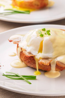 Kahvaltı Yumurta Benedict - tost İngilizce muffins, pastırma, jambon, haşlanmış yumurta, otlar ve lezzetli tereyağı hollandaise sosu olduğunu. 