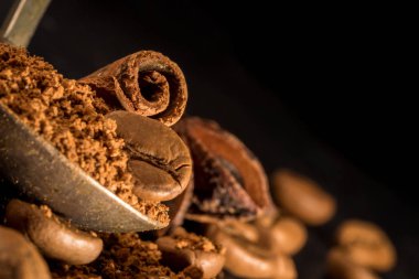 vintage bir çekilmiş kahve kaşığı tarçın sopayla. baharat ile kahve. Gıda arka plan üzerinde koyu taş tablo. Makro yakın çekim yansıma.