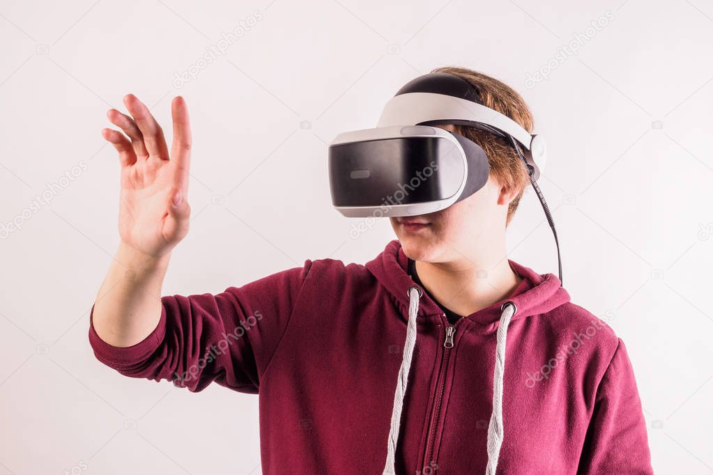 Teenage student man virtual reality headset or 3d glasses, playing video game, gesturing with his hands and catching something. Technology, gaming, entertainment and people concept.