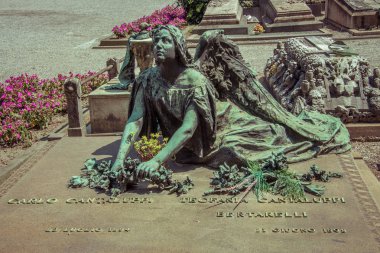 CHELYABINSK, RUSSIA - June 07,2017 Milan, Italy. Famous landmark - old grave at the Monumental Cemetery (Cimitero Monumentale). Religious art. clipart
