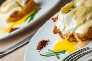 Kahvaltı Yumurta Benedict - tost İngilizce muffins, pastırma, jambon, haşlanmış yumurta, otlar ve lezzetli tereyağı hollandaise sosu olduğunu. 