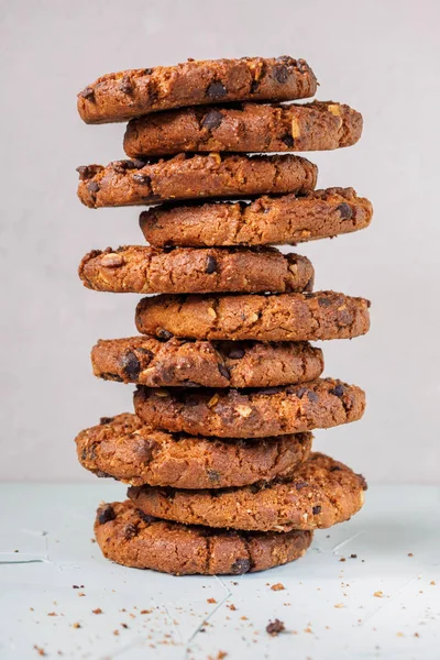 Chocolate chip cookies on white background. Stacked chocolate chip cookies on brown napkin. Symbolic image with place for text. Freshly baked. Concept for a tasty snack. Sweet dessert. Selective focus. Close up.