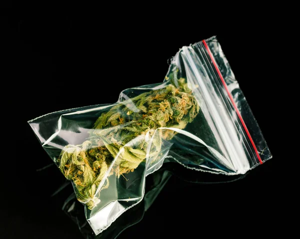 Tütchen mit Marihuana auf schwarzem Hintergrund. — Stockfoto