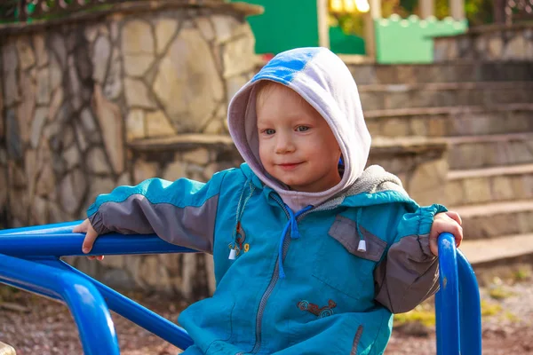 Счастливый европейский мальчик, сидящий на разноцветной детской пле — стоковое фото