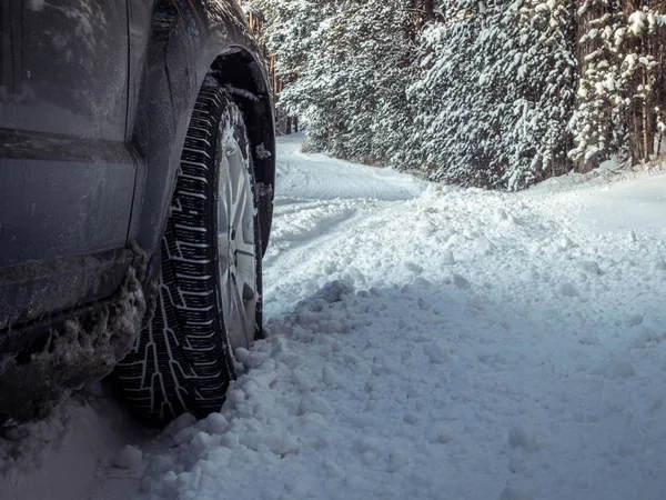 Car tires on winter road covered with snow. Vehicle on snowy all