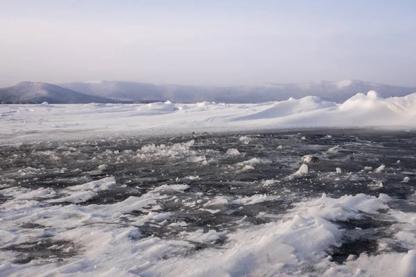 Natural winter lake ice breaking with clear sky background, sele