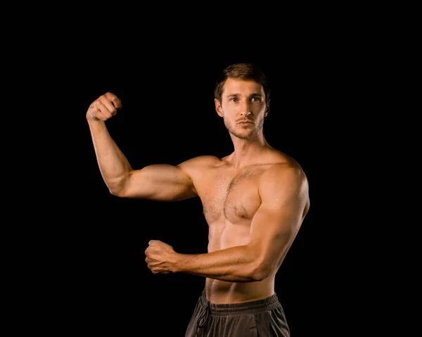 Modelo muscular joven sobre fondo negro aislado. Varita deportiva — Foto de Stock