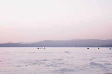 Balıkçılarla ve kış gölü üzerindeki çadırlarla manzara 