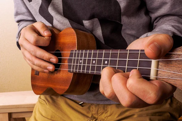 Mężczyzna gra na gitarze ukulele w zbliżeniu widok. — Zdjęcie stockowe