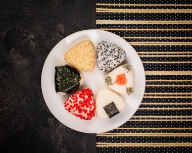 farklı el yapımı onigiri yakın plan. Japon mutfağı, Asya vejetaryen menüsü. Bir sürü malzeme - nori, biber, pilav, susam, chia. Üst görünüm.