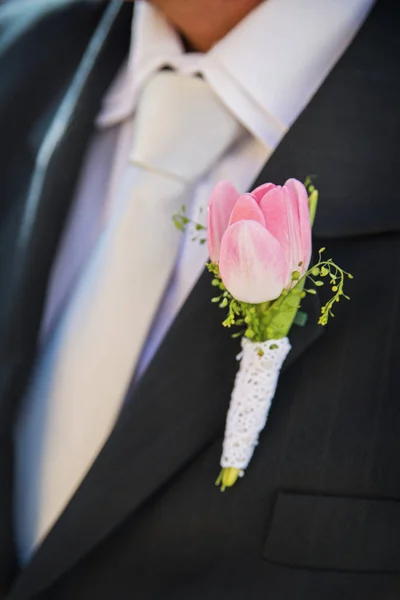 groom in a jacket decorated with a wedding feather from a tulip flower