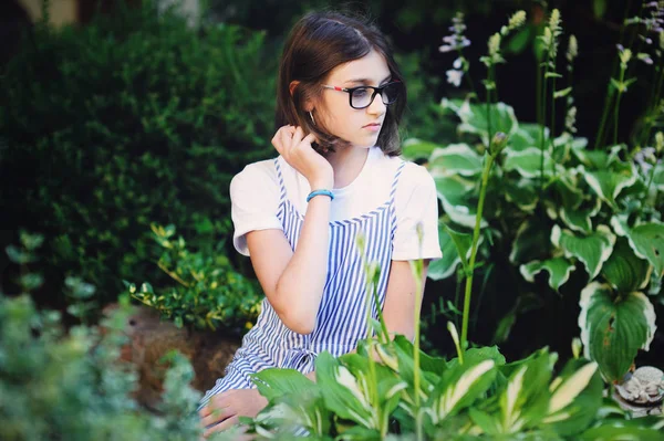 Cantik tersenyum gadis remaja dengan blus biru, melawan hijau taman musim panas. — Stok Foto